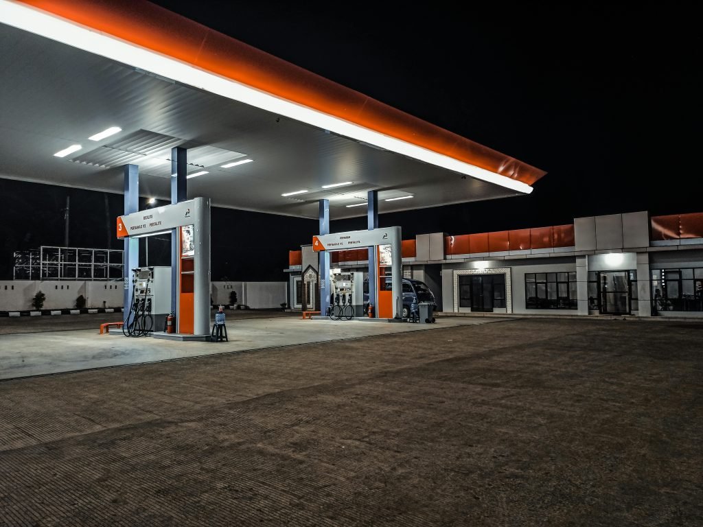 A contemporary gas station illuminated at night, highlighting pump stations and canopy.